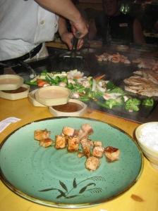 Teppanyaki chicken at Asuka, with more meat and veggies on the grill in the background.