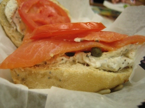 Close-up of bagel with cream cheese and lox from Bloomington Bagel Company, with capers between the lox and cream cheese.