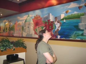 Kira, looking at a mural at the Bloomington Sandwich Co.