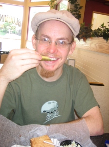 Erik eating a pickle at Bloomington Sandwich Co.